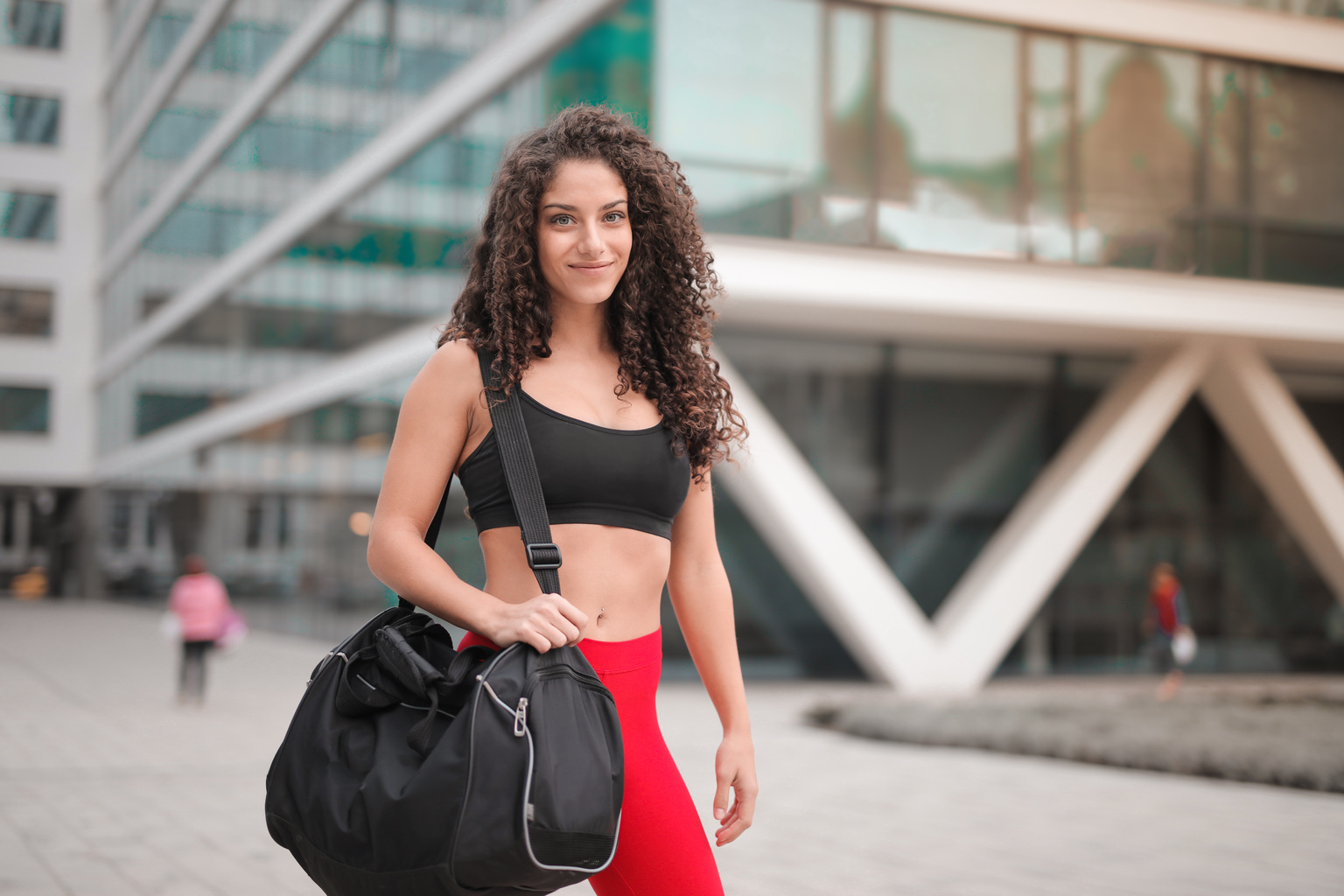 Selective Focus Photo of Smiling Woman In Active Wear Carrying Gym Bag